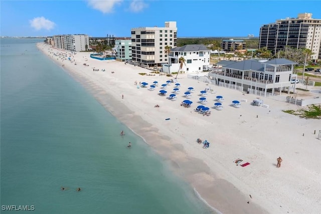 drone / aerial view featuring a beach view and a water view