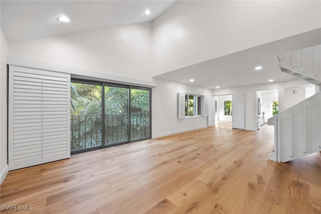 unfurnished living room featuring light wood finished floors, recessed lighting, a wealth of natural light, and baseboards