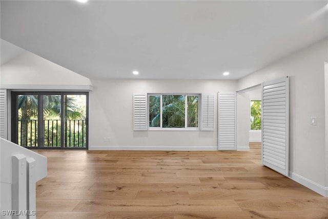 spare room with recessed lighting, a wealth of natural light, and light wood-style floors