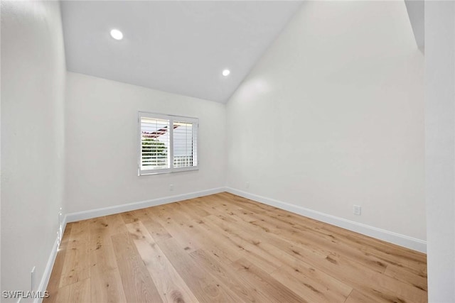 unfurnished room with lofted ceiling, light wood-style flooring, baseboards, and recessed lighting