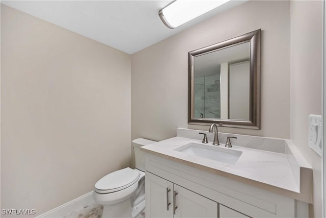 bathroom with toilet, baseboards, and vanity