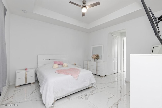 bedroom featuring ceiling fan and a tray ceiling