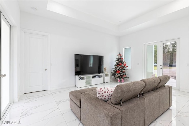 living room featuring french doors and a raised ceiling