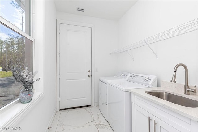 washroom featuring cabinets, sink, and independent washer and dryer