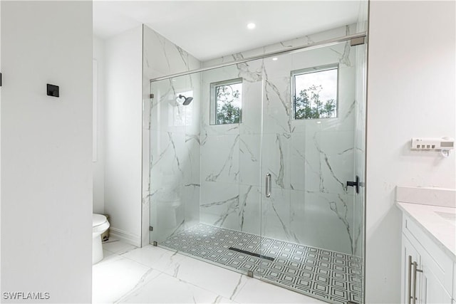 bathroom featuring vanity, a shower with door, and toilet