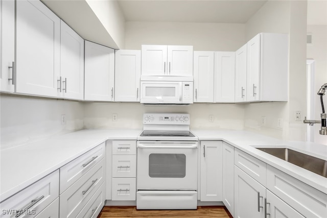 kitchen featuring white cabinetry, sink, dark wood-type flooring, and white appliances