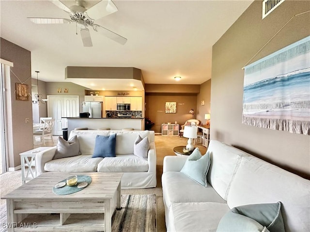 living room with ceiling fan and carpet flooring