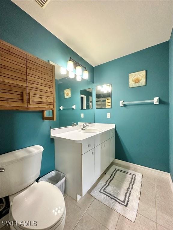 bathroom with vanity, tile patterned floors, and toilet