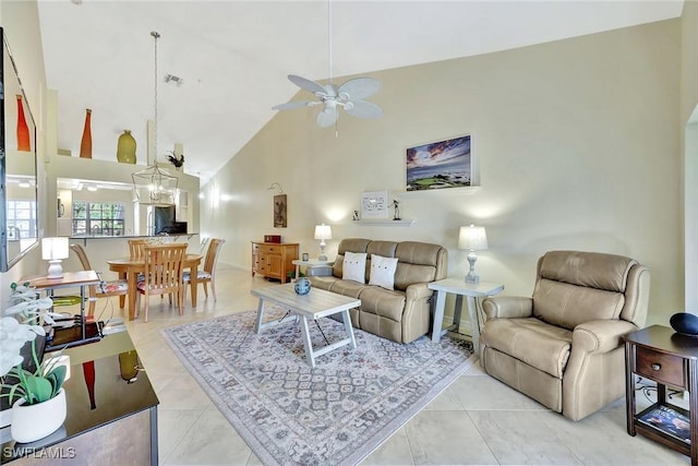 living room featuring ceiling fan with notable chandelier, high vaulted ceiling, and light tile patterned flooring