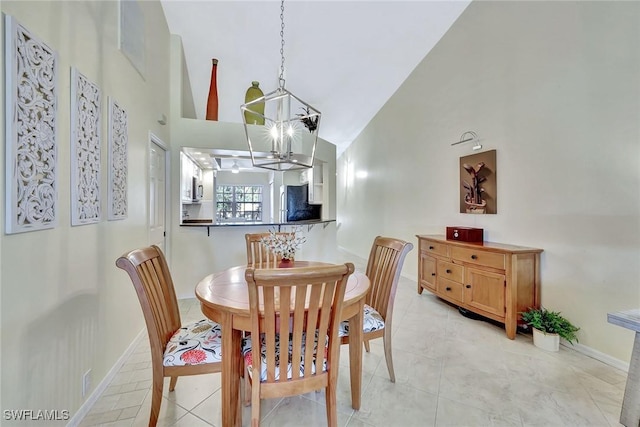 dining room featuring an inviting chandelier, light tile patterned flooring, and high vaulted ceiling