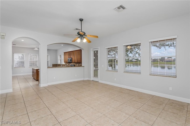 unfurnished living room featuring light tile patterned floors and ceiling fan