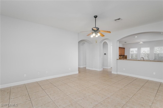 empty room with light tile patterned floors and ceiling fan