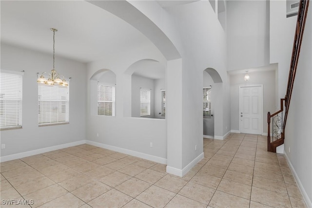 spare room with light tile patterned floors and an inviting chandelier