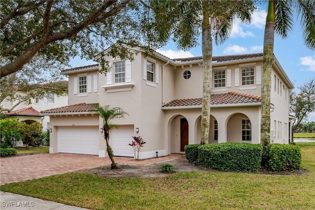 mediterranean / spanish home with a garage and a front yard