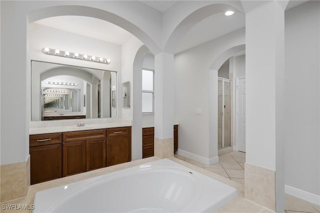 bathroom with vanity, tile patterned flooring, and plus walk in shower