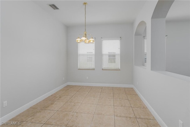 unfurnished room featuring light tile patterned floors and a chandelier