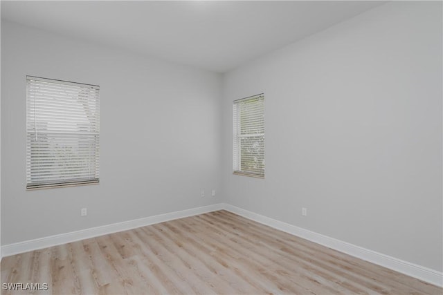 empty room with plenty of natural light and light hardwood / wood-style flooring