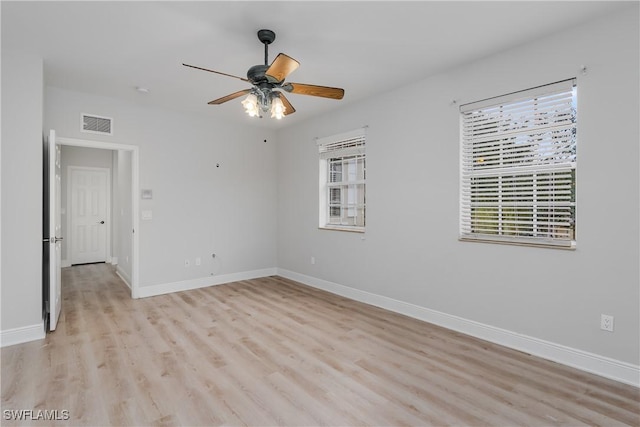 unfurnished room with a wealth of natural light, ceiling fan, and light wood-type flooring