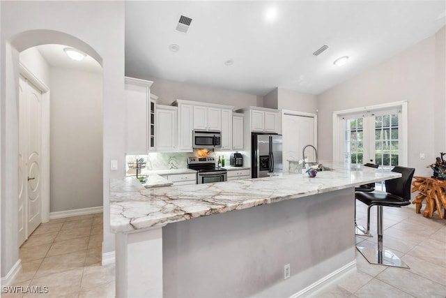 kitchen featuring a spacious island, a breakfast bar, white cabinets, and appliances with stainless steel finishes