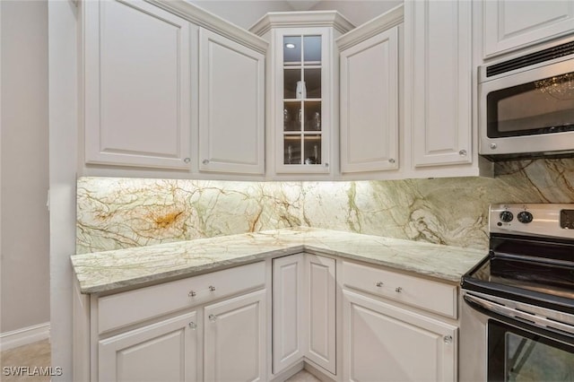 850 25th St SW, Naples, FL 34117 - kitchen featuring stainless steel appliances, tasteful backsplash, white cabinetry, and glass insert cabinets