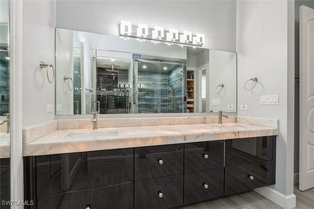 850 25th St SW, Naples, FL 34117 - bathroom featuring double vanity, a stall shower, baseboards, a walk in closet, and wood finished floors