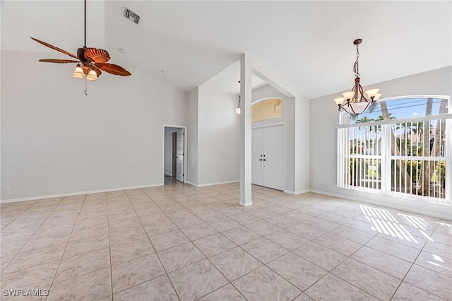 unfurnished room with light tile patterned flooring, ceiling fan with notable chandelier, and high vaulted ceiling