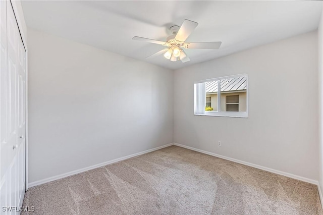 unfurnished room with ceiling fan and carpet