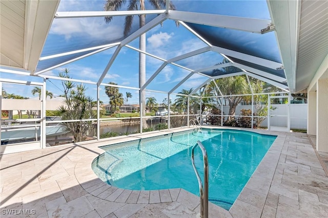 view of pool with a water view, a patio, and a lanai