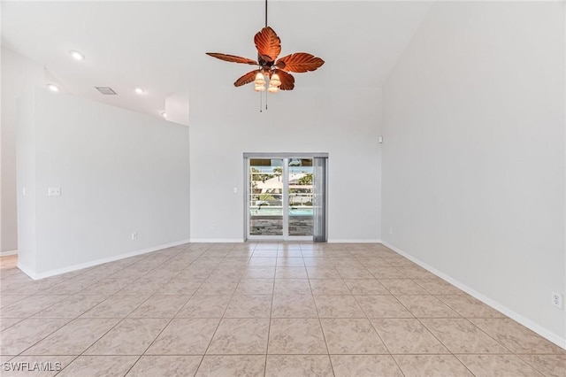 unfurnished room with light tile patterned floors, ceiling fan, and a high ceiling