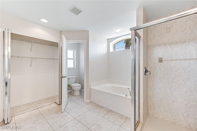 bathroom with tile patterned floors, toilet, and a healthy amount of sunlight