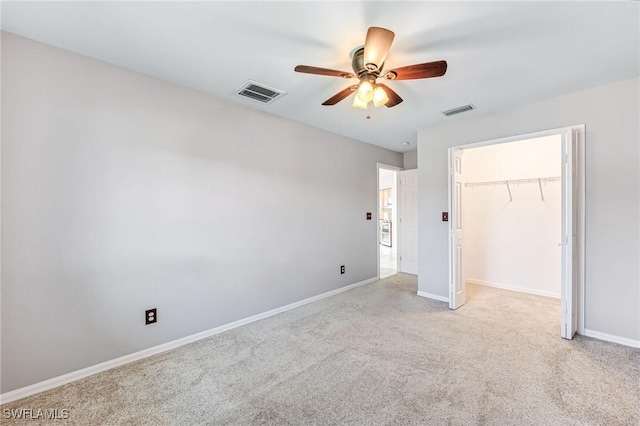 unfurnished bedroom featuring a walk in closet, ceiling fan, and a closet