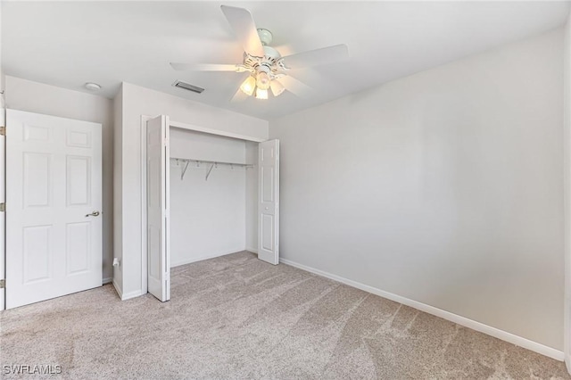 unfurnished bedroom with ceiling fan, light carpet, and a closet