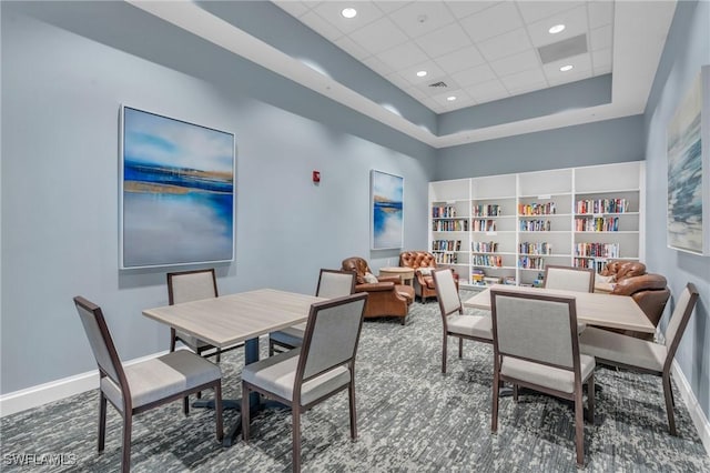 carpeted dining space featuring a drop ceiling