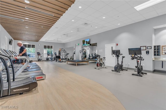 gym featuring a drop ceiling and light hardwood / wood-style floors