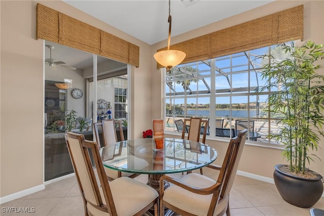 12890 Kentfield Ln, Fort Myers, FL 33913 - dining room featuring a sunroom, a water view, baseboards, and light tile patterned floors