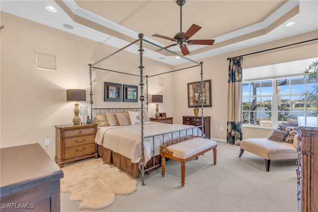 bedroom featuring ornamental molding, light colored carpet, a raised ceiling, and ceiling fan