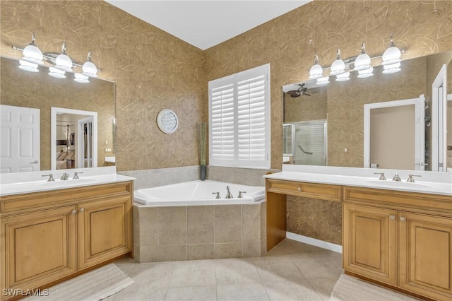 bathroom with tile patterned floors, tiled bath, and vanity