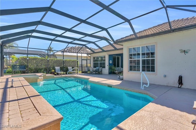 view of swimming pool featuring an in ground hot tub, a lanai, and a patio area