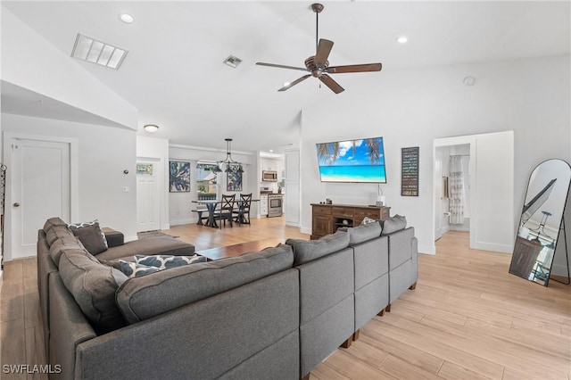 living room featuring lofted ceiling, light hardwood / wood-style floors, and ceiling fan