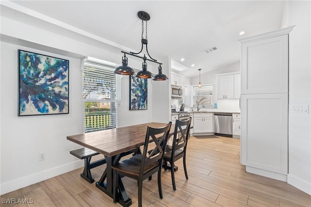 dining area with lofted ceiling and sink