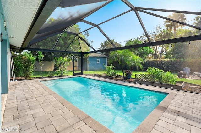 view of swimming pool featuring a lanai, a patio area, and a storage unit