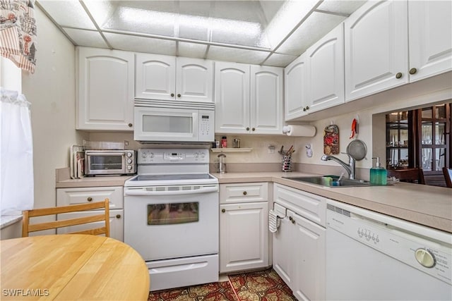 kitchen with sink, white appliances, and white cabinets