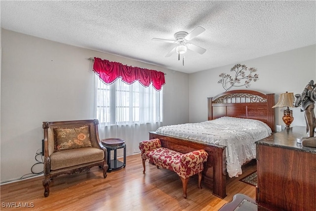 bedroom featuring wood-type flooring, a textured ceiling, and ceiling fan