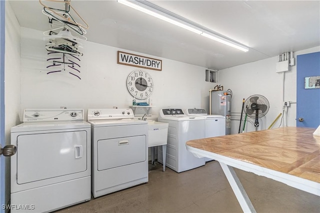 laundry room with washing machine and dryer, electric water heater, and sink