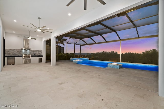 pool at dusk featuring ceiling fan, grilling area, and pool water feature