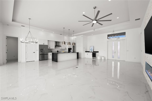 kitchen featuring white cabinetry, stainless steel fridge with ice dispenser, a tray ceiling, and hanging light fixtures