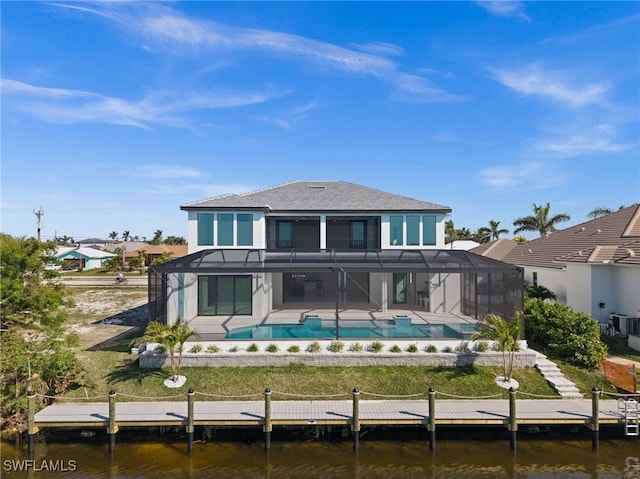 rear view of house with a water view, a lanai, central AC, and a patio area