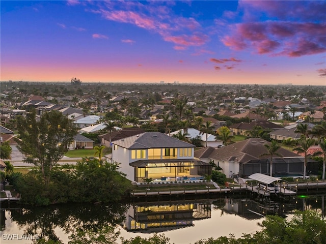 aerial view at dusk featuring a water view