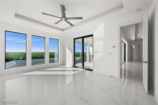 unfurnished room with ceiling fan and a raised ceiling