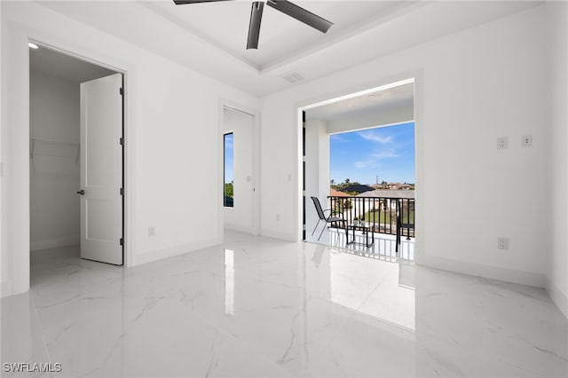 unfurnished room with a raised ceiling and ceiling fan